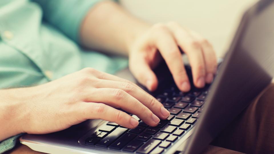 hands typing on laptop keyboard