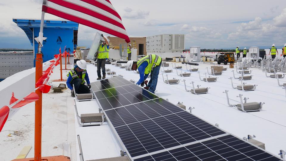 solar panel installers working on the roof of a building