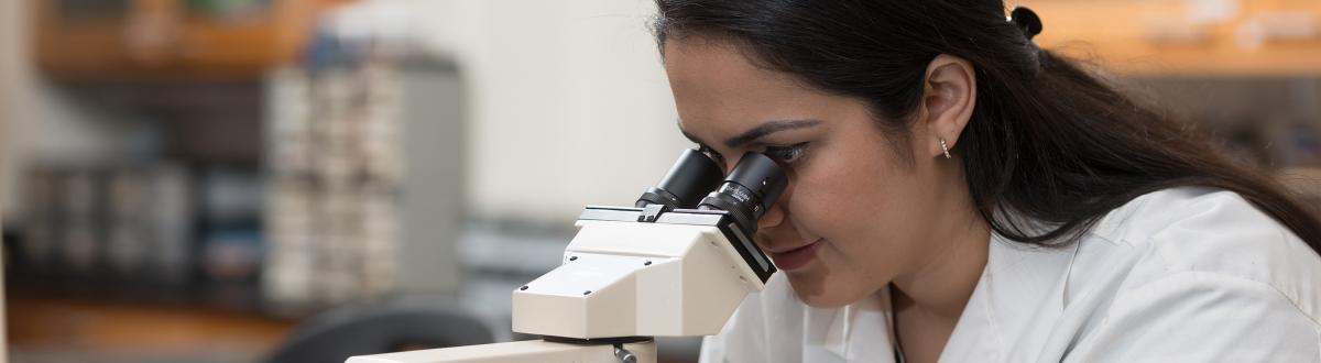 female looking into microscope