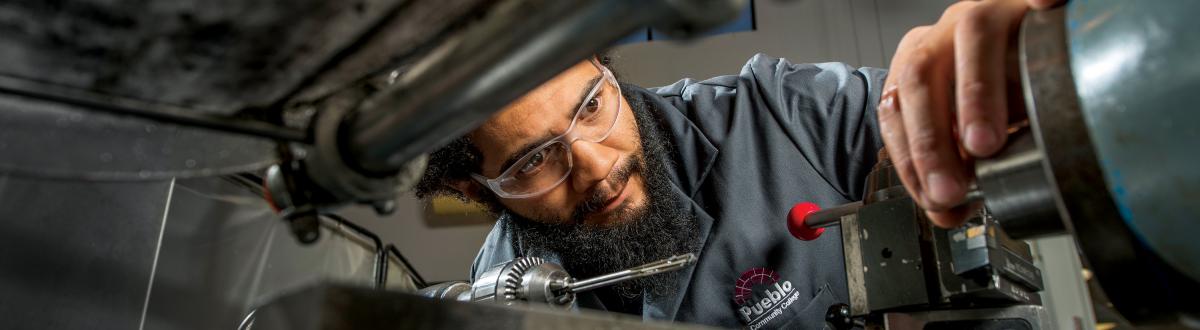 Machining student using machining equipment