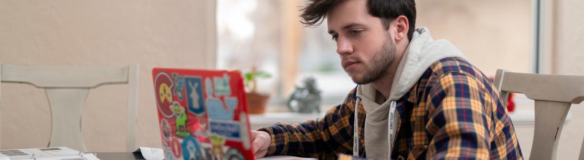 Male student at home with laptop