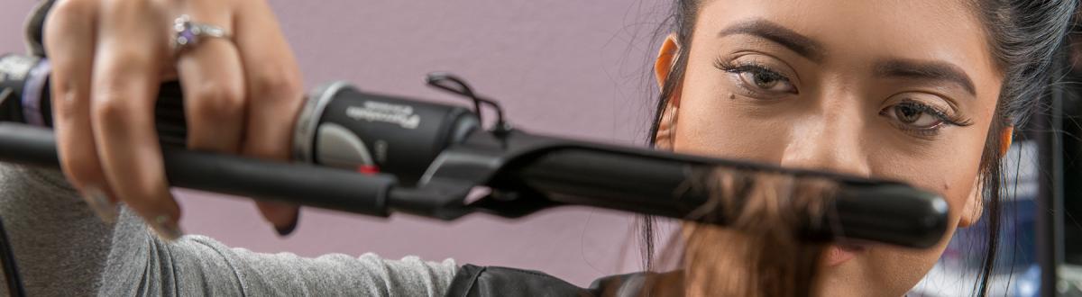 Cosmetology student using a styling tool