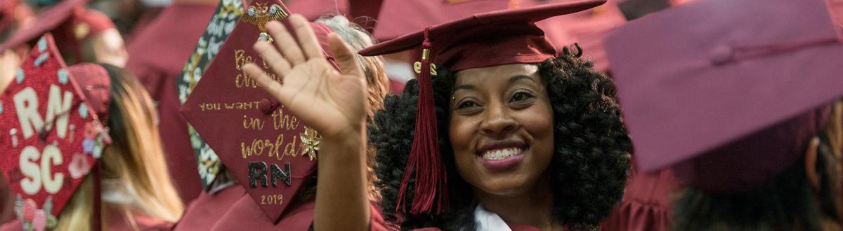 PCC graduate waving during commencement ceremony