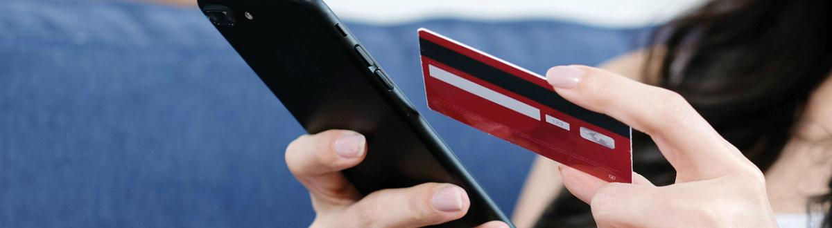 Woman holding a credit card and cell phone