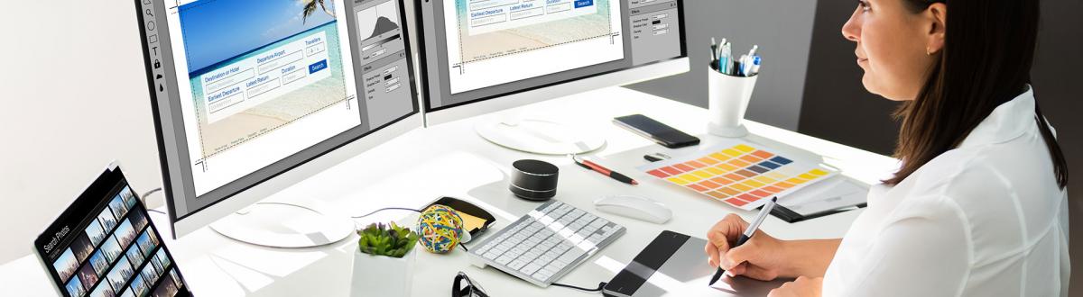 Woman in front of multiple computer monitors