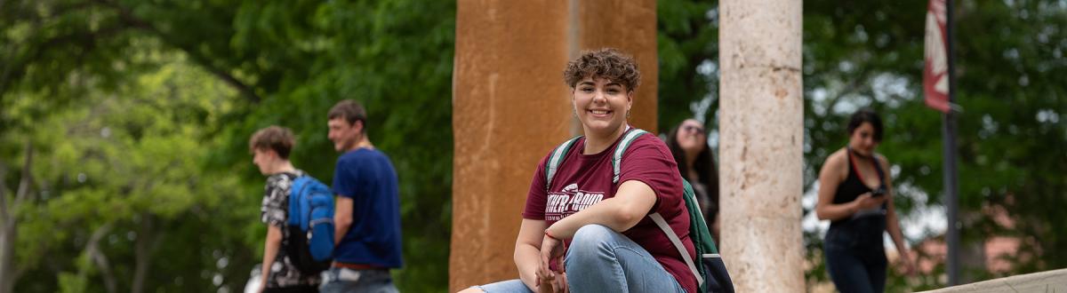 Gateway to College student sitting in courtyard on the Pueblo Campus