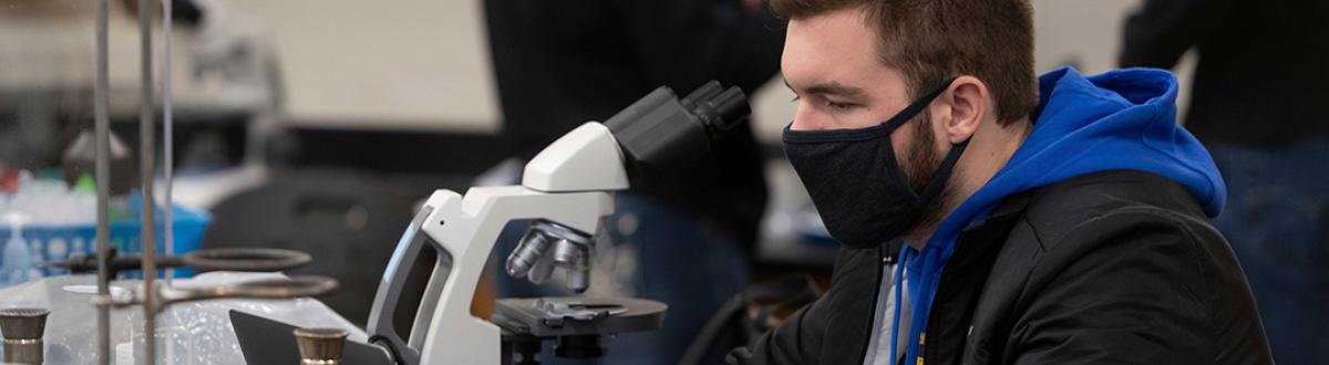male student at microscope